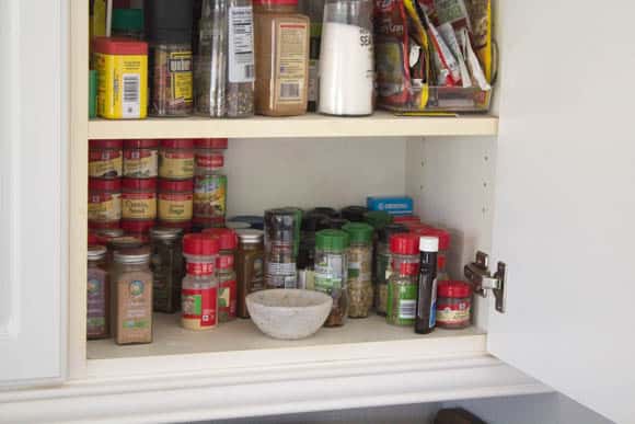 The before shot of our unorganized spice cabinet. 