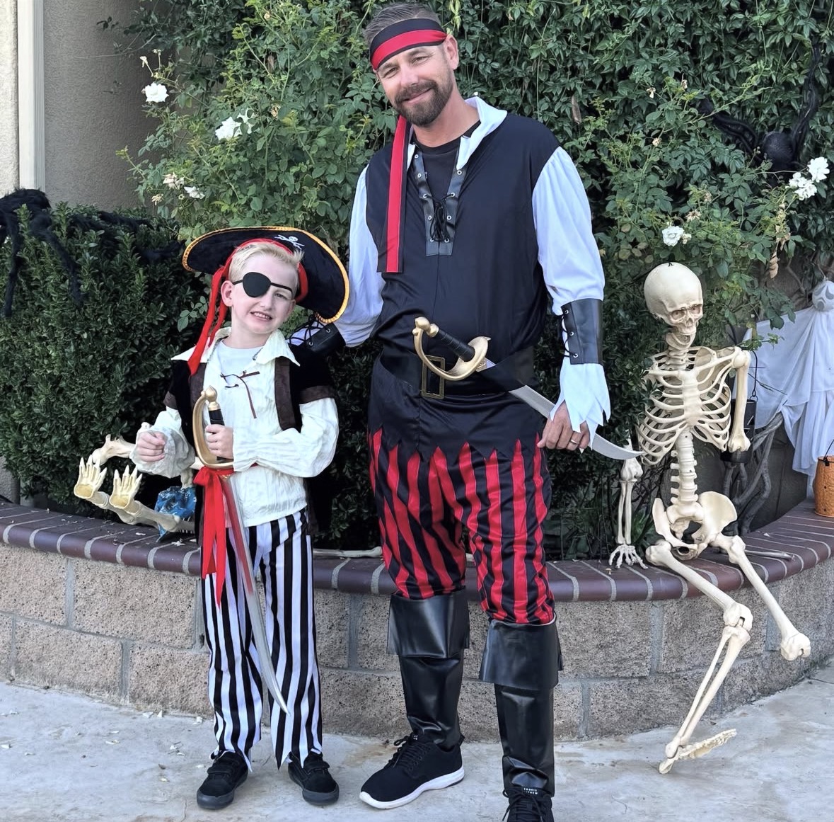 Dad dressed as pirate and some dressed as a pirate holding a sword.