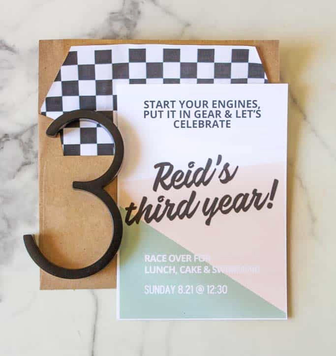 Modern race car birthday invitation with checkerboard envelope liner